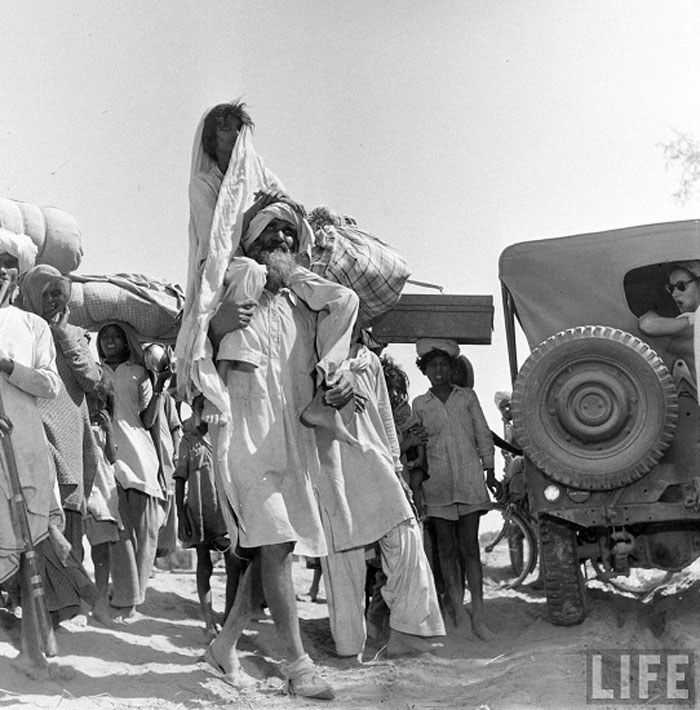 A Sikh carrying his wife on his shoulders